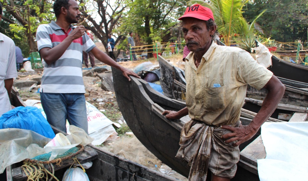 An "expert" fisherman negotiates with locals to settle on a good price for his morning catch. (Photo by Victoria Nechodomu, Nechodomu Media)
